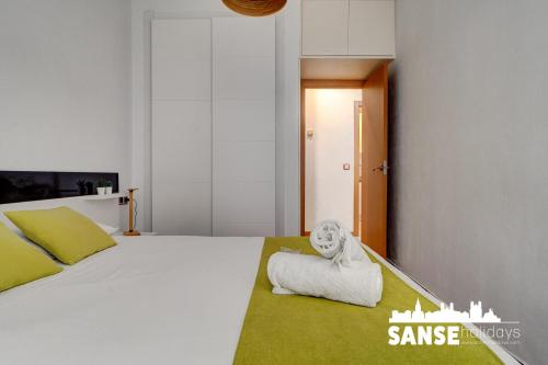 a bedroom with a white bed with a towel at Apartamento Karri by SanSe Holidays in San Sebastián