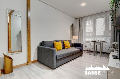 a living room with a gray couch with yellow pillows at Apartamento Karri by SanSe Holidays in San Sebastián