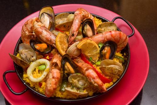 a bowl of shrimp and mussels on a pink plate at Ibis Abdelmoumen Casa Centre in Casablanca