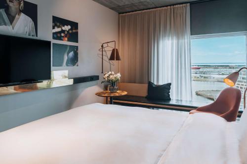 a hotel room with a bed and a large window at Story Hotel Studio Malmo, part of JdV by Hyatt in Malmö
