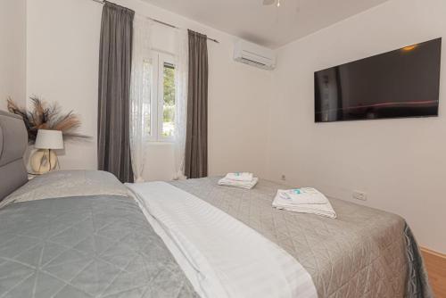 a bedroom with a bed with a tv on the wall at Apartment Mozart in Šibenik