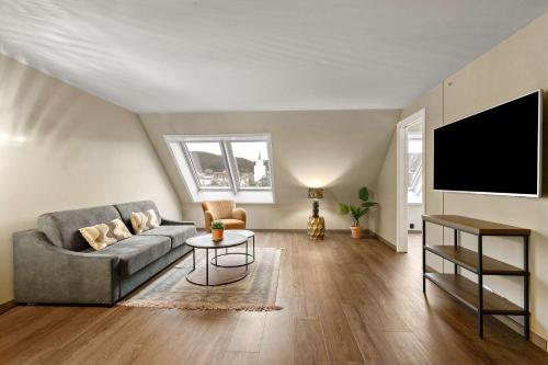 a living room with a couch and a flat screen tv at Ole Bull, Best Western Signature Collection in Bergen