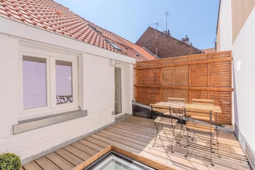 terraza de madera con sillas y mesa en el balcón en 2 BR house w/ terrace, near train stations & metro, en Lille