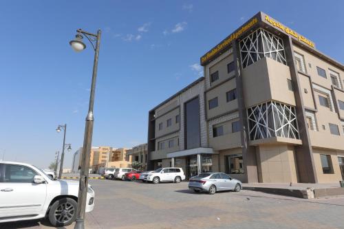 a parking lot with cars parked in front of a building at Dar Hashim Al Nuzha Serviced Apartments - Economic in Riyadh