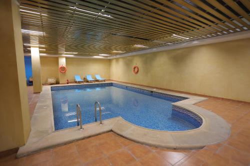 a large swimming pool in a building with a pool at Dar Hashim Hotel Suites - Alnuzha in Riyadh