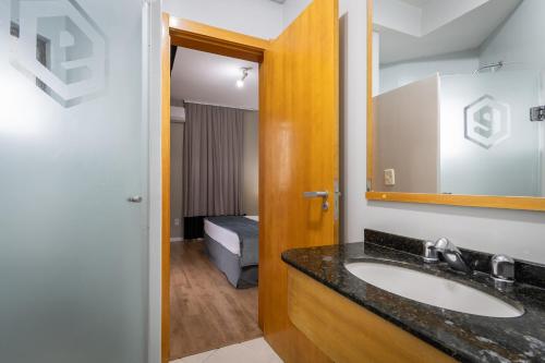 Brivali Hotel e Eventos في Caçador: حمام مع حوض ومرآة