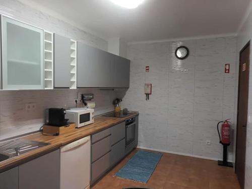 a kitchen with a sink and a microwave on a counter at Casa Miradouro in Ribeira Grande