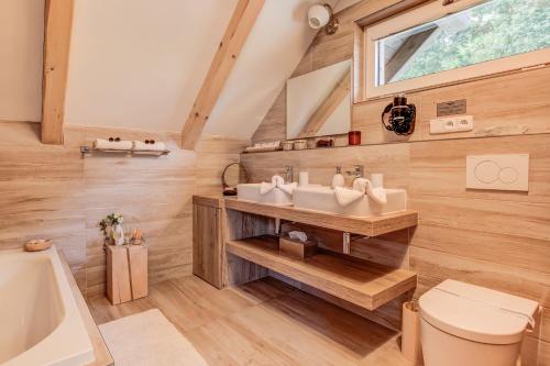 łazienka z umywalką, toaletą i oknem w obiekcie Wellness apartmány Český ráj & Biokolna w mieście Lomnice nad Popelkou