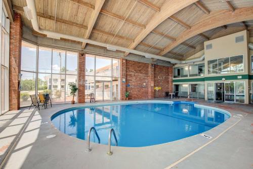 a swimming pool in a building with a large ceiling at Howard Johnson by Wyndham Branson Theatre District in Branson