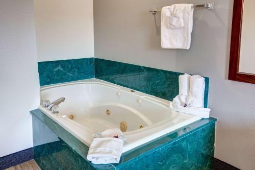 a bathroom with a bath tub with blue tile at Howard Johnson by Wyndham Branson Theatre District in Branson