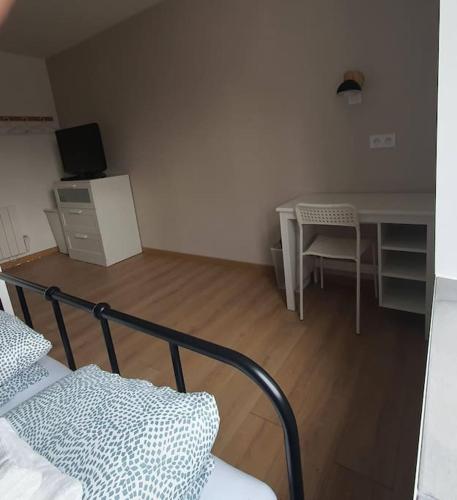 une chambre avec un lit, une table et un bureau dans l'établissement Le Coquelicot : appartement T1, à Héricourt