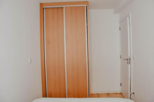 een kast met een houten deur in een slaapkamer bij Veiga apartment (self check in) in Coimbra