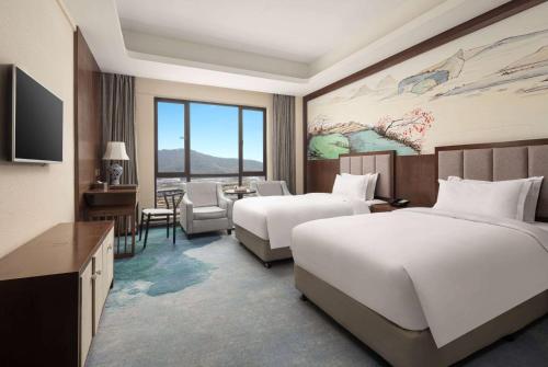 Habitación de hotel con 2 camas y TV en Days Inn by Wyndham Hangzhou Zhuantang, en Hangzhou