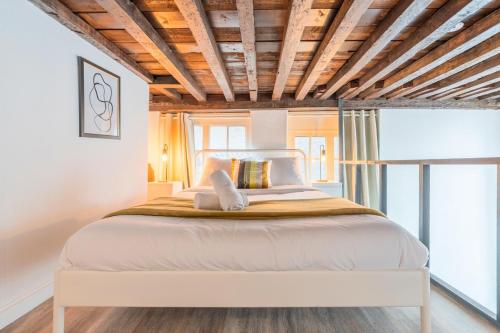 - une chambre avec un grand lit et des plafonds en bois dans l'établissement Atypical triplex near Grand Place with terrace, à Lille