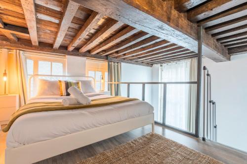- une chambre avec un grand lit et des plafonds en bois dans l'établissement Atypical triplex near Grand Place with terrace, à Lille