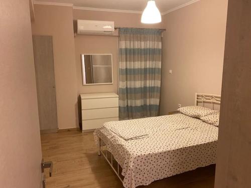 een kleine slaapkamer met 2 bedden en een raam bij Lovely apartment 2’ walking from Anavyssos beach in Anavissos