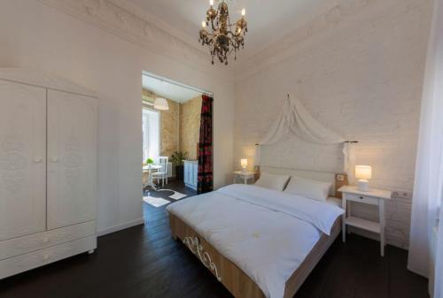 a bedroom with a large bed and a chandelier at Kyiv Prince Apartment in Kyiv