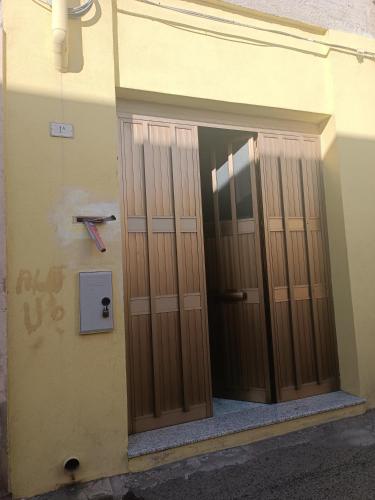 due porte in legno sul lato di un edificio di Casa Cristina a Quartu SantʼElena