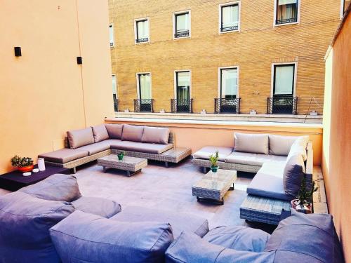 a large patio with couches and tables and a building at RESIDENZA 62 in Rome