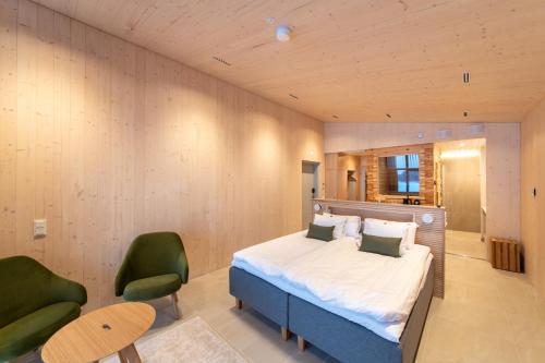 um quarto com uma cama e 2 cadeiras verdes em Bella Lake Resort em Kuopio