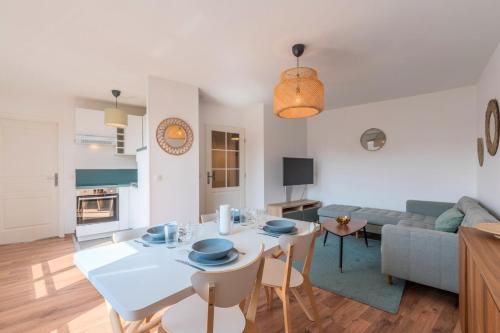 a living room with a white table and a couch at Quiet 1 bedroom apartment parking Old Lille in Lille