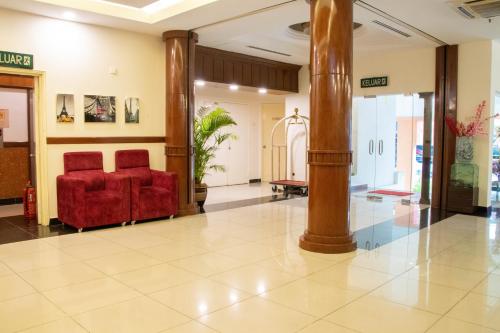 um lobby com uma cadeira vermelha e um pilar em bintang hotel em Kuala Lumpur
