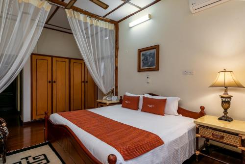 a bedroom with a bed and a desk with a lamp at Mweya Safari Lodge in Katwe