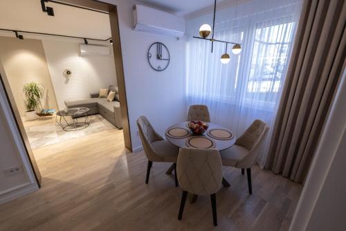 ein Esszimmer mit einem Tisch und Stühlen sowie ein Wohnzimmer in der Unterkunft Vividlux Apartments in Aranđelovac
