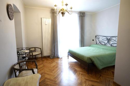 a bedroom with a green bed and a table and chairs at Case Ospitali - Corte Nuova appartamento in corte storica con due camere e due bagni in Caponago