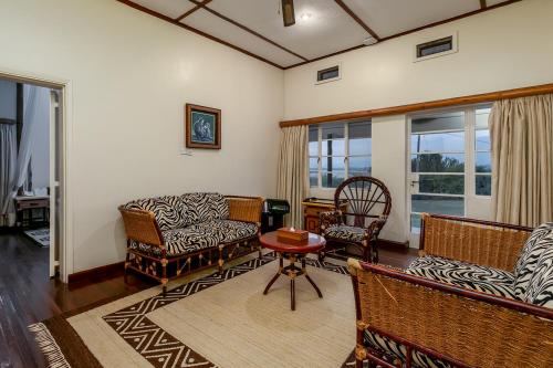 a living room with a couch and chairs and a table at Mweya Safari Lodge in Katwe