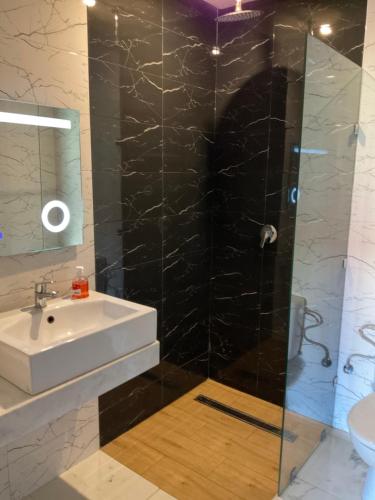 a bathroom with a sink and a shower at Playa Del Sol Surf House in Tamraght Ouzdar