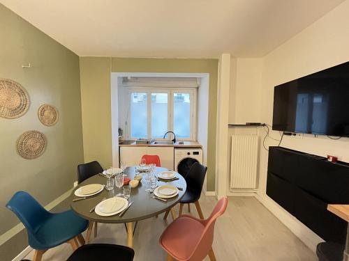 une salle à manger avec une table, des chaises et une télévision dans l'établissement Comtes du Maine - Centre - Parade des pilotes - 6 pers, au Mans