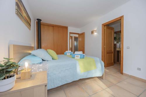 a bedroom with a bed with blue and yellow pillows at Can Bennasar in Can Picafort