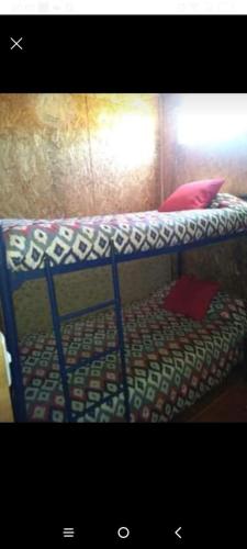 - un lit superposé avec des oreillers rouges dans l'établissement Departamento en Las Cruces, à El Tabo