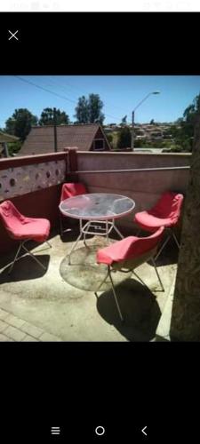d'une terrasse avec une table et des chaises rouges. dans l'établissement Departamento en Las Cruces, à El Tabo