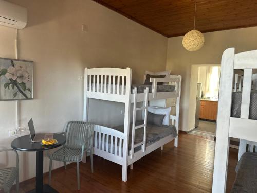 a living room with two bunk beds and a table at Hostel on the Hill - by Filikuri Beach in Himare