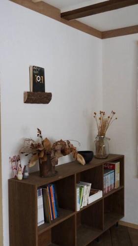 a book shelf with books and a clock on the wall at ８名までOK／尻別岳を一望／ルスツリゾートまで車で９分／SISUMO鈴川 in Kimobetsu