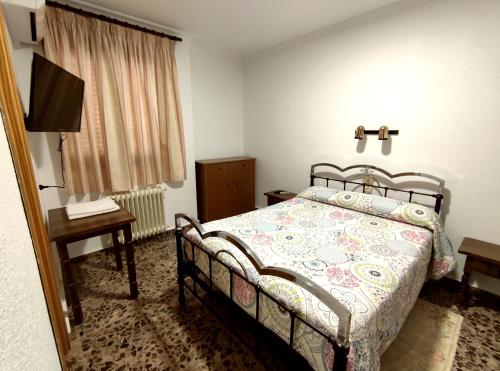 Schlafzimmer mit einem Bett, einem Tisch und einem TV in der Unterkunft Hostal El Molino in Villahermosa