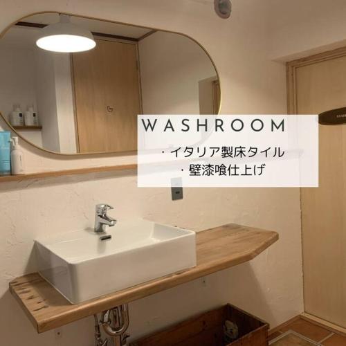 a bathroom with a sink and a mirror at ８名までOK／尻別岳を一望／ルスツリゾートまで車で９分／SISUMO鈴川 in Kimobetsu