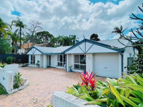 a house with a blue roof and a brick driveway at Cheerful 5 Bedroom Holiday Destination in Browns Plains