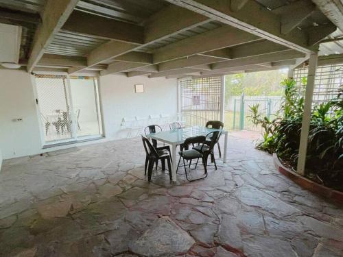 a patio with a table and chairs in a room at Cheerful 5 Bedroom Holiday Destination in Browns Plains