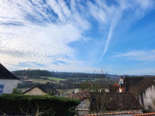 ein blauer Himmel mit Wolken über einem Dorf in der Unterkunft la chambre d'Axelle in La Bachellerie