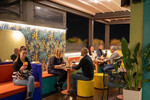 a group of people sitting at tables in a restaurant at Hotel Montecarlo in Rome