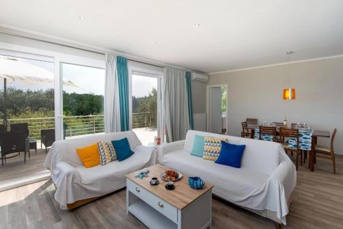 a living room with a couch and a table at Elisabetta Villa by PaxosRetreats in Gaios