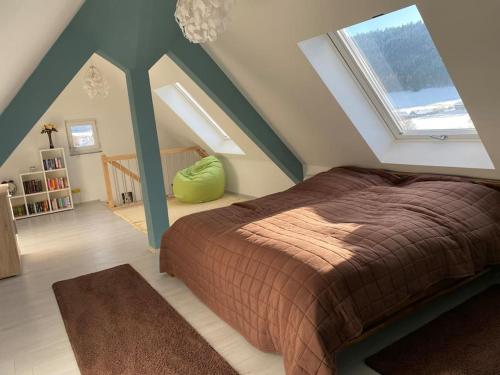 Loft Wohnung mit toller Aussicht في Meßstetten: غرفة نوم بسرير كبير في العلية