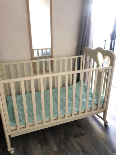 - un lit bébé blanc dans une chambre avec fenêtre dans l'établissement Stella Marina, à Marsala