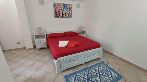 1 dormitorio pequeño con 1 cama con manta roja en La Casa di Paolo, en Terralba