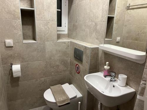 a bathroom with a toilet and a sink at Agorakritou Magic Corner in Athens