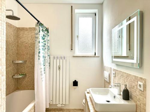 y baño con lavabo, bañera y aseo. en E&K living - city central - design apartment - kitchen - free parking, en Gersthofen