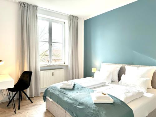 1 dormitorio con cama, escritorio y ventana en E&K living - city central - design apartment - kitchen - free parking, en Gersthofen